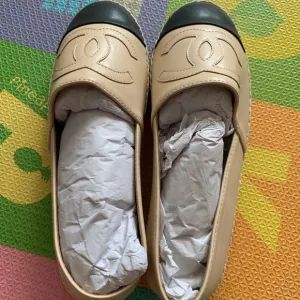 CHANEL Cream and Black Loafers with Elegant Cap Toe